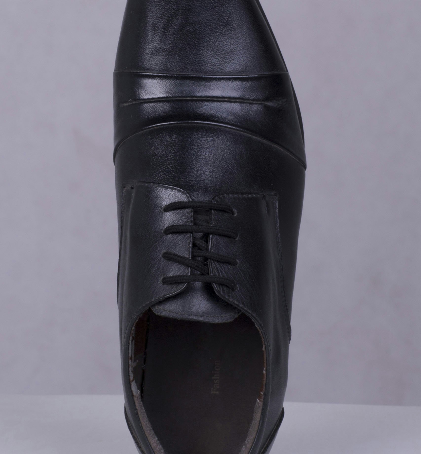 footwear-retouching-shoelace-fix-before Overhead view of black leather shoe with messy laces